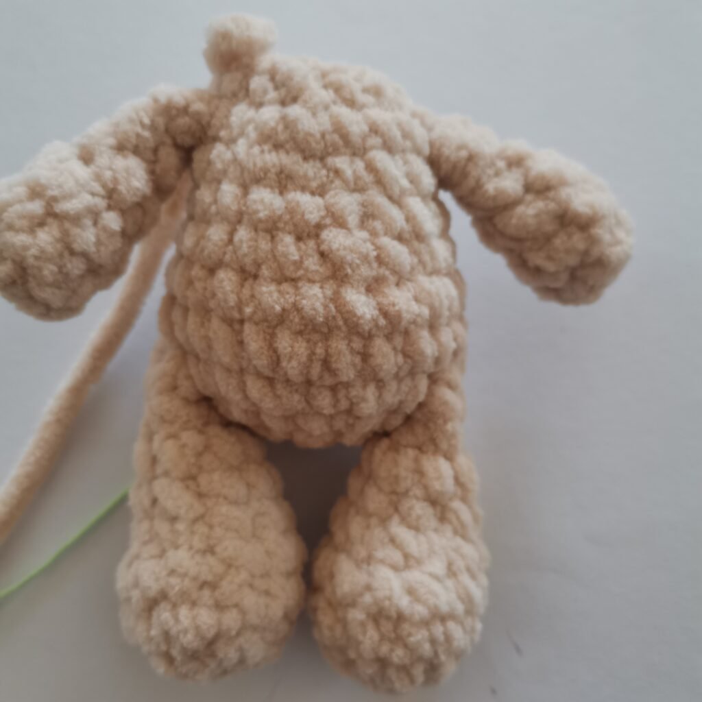 Close-up of a cream-colored crochet bunny body made with soft plush yarn.