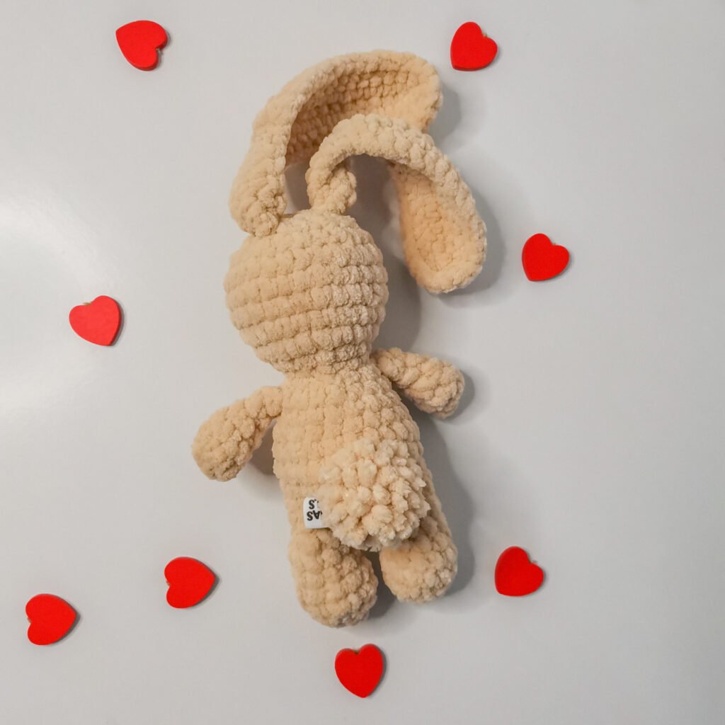 Free Plush Bunny Crochet Pattern Close-up of a cream-colored crochet bunny made with soft plush yarn from back.