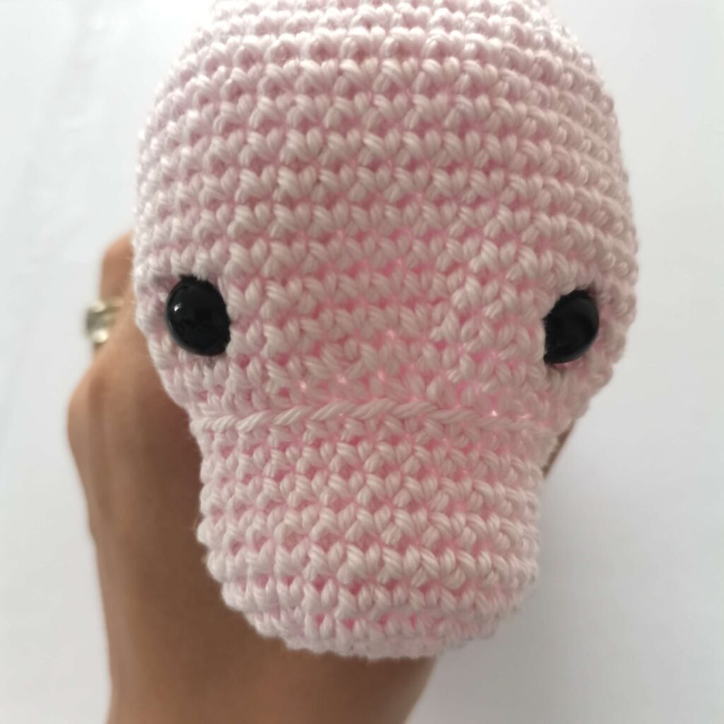 head of crochet magical unicorn with big black eyes