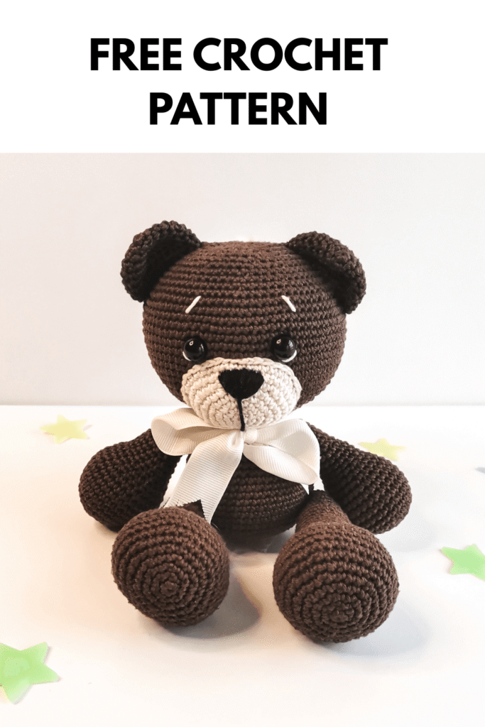 Classic brown crochet teddy bear with a cream muzzle and white satin bow. Text "FREE CROCHET PATTERN" on the top.