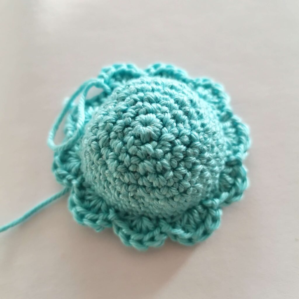Crocheted semi-circle in blue shade for mini reversible octopus.