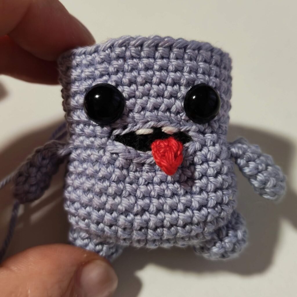 Inserting safety eyes for amigurumi rocker monster pencil topper.
