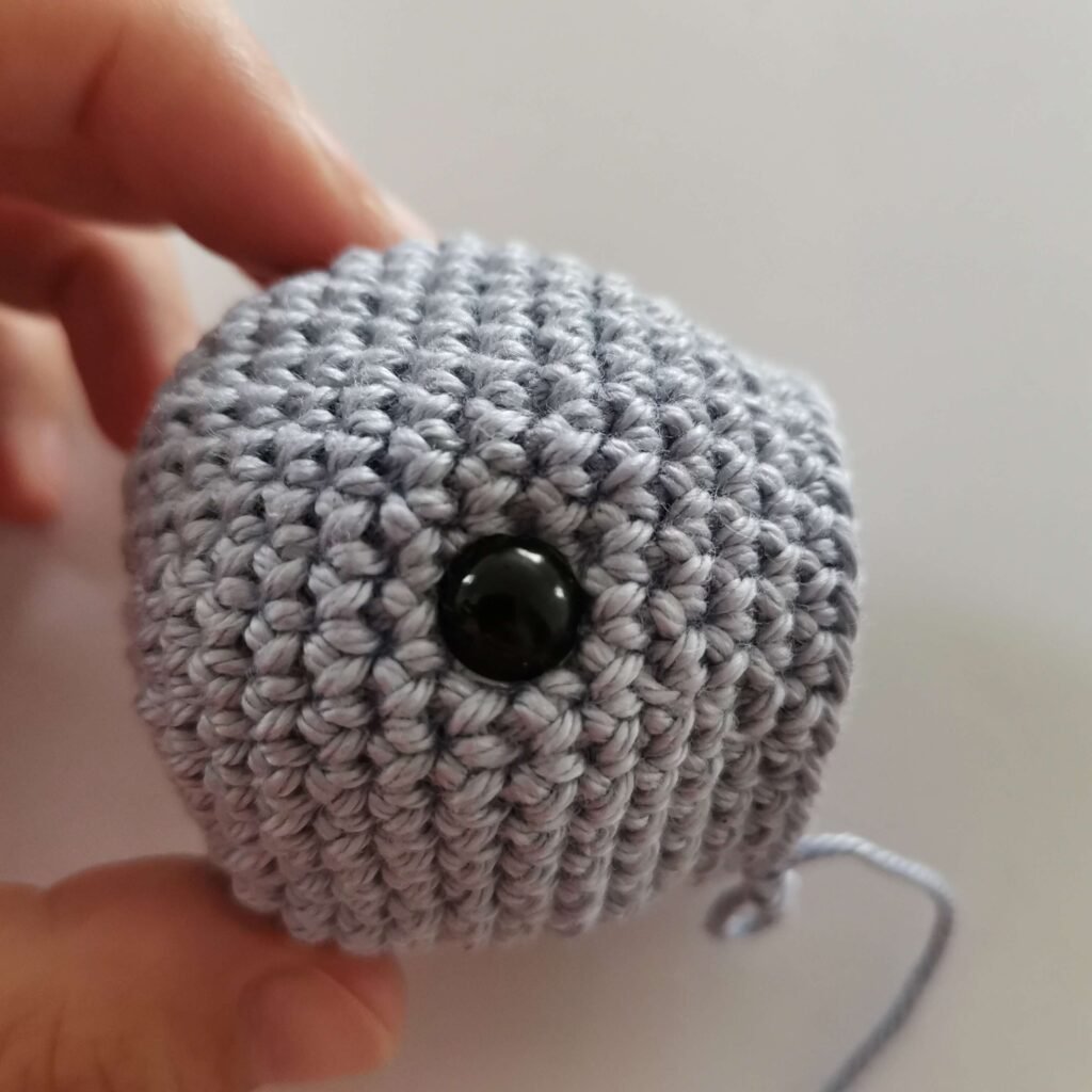 Placing saffety eyes on Crochet Baby Whale Rattle