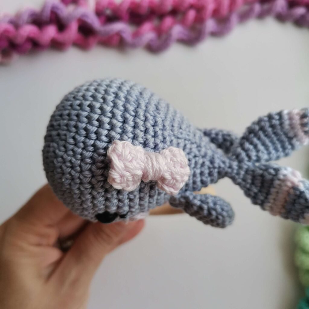 Bow on top of crochet baby whale head.