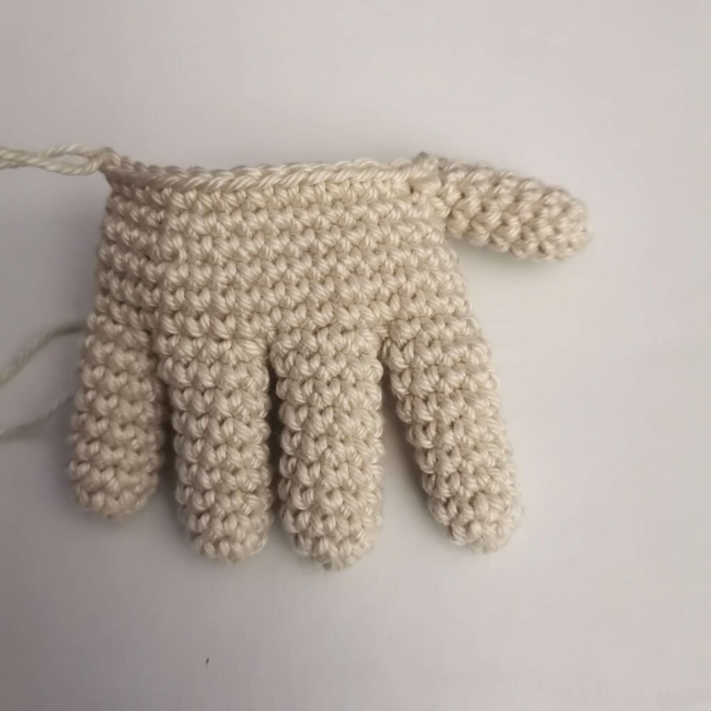 Crocheted thumb attached to the hand palm for the creepy Halloween hand pattern.