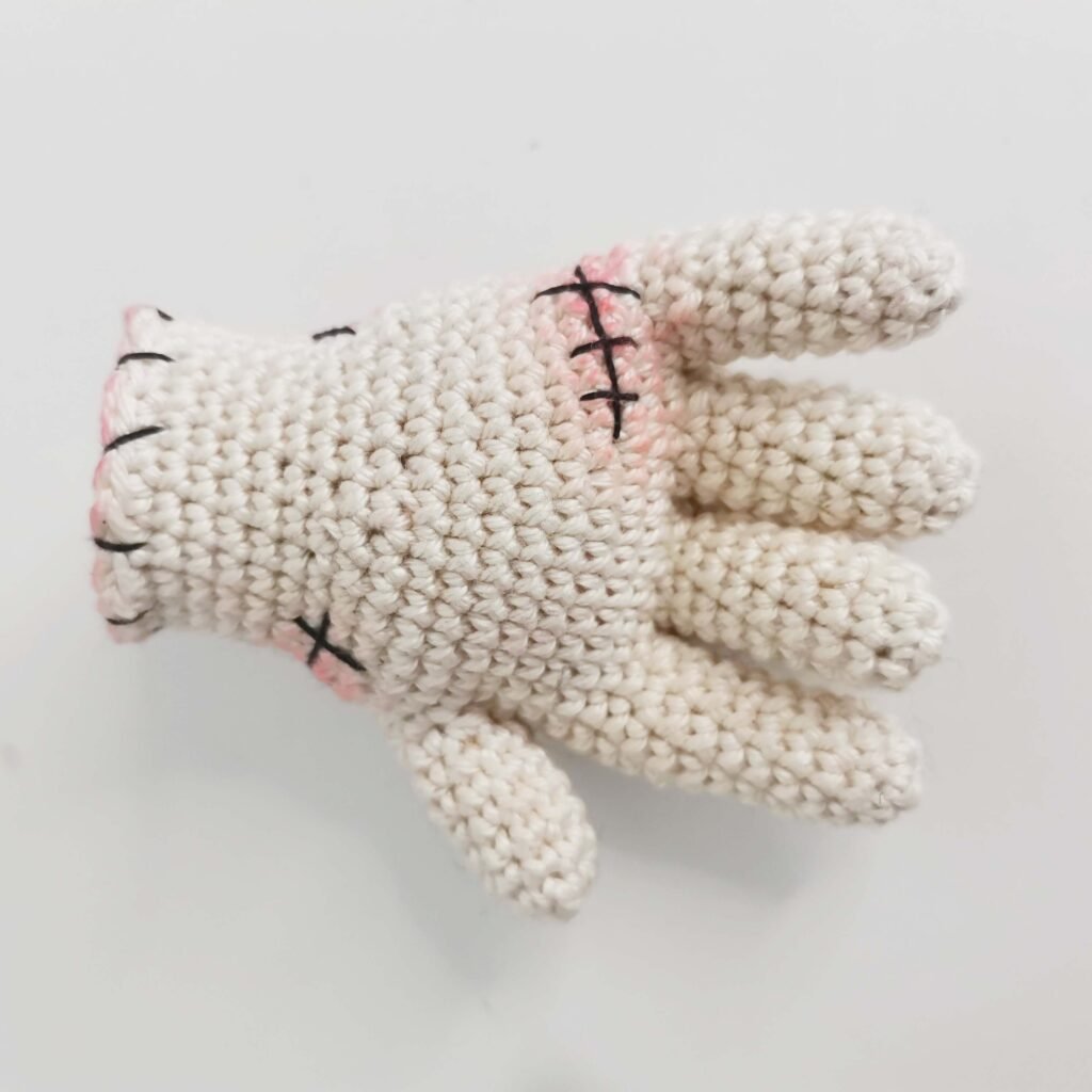 Back side of the crocheted stitched hand featuring detailed embroidered stitches for Halloween decor.